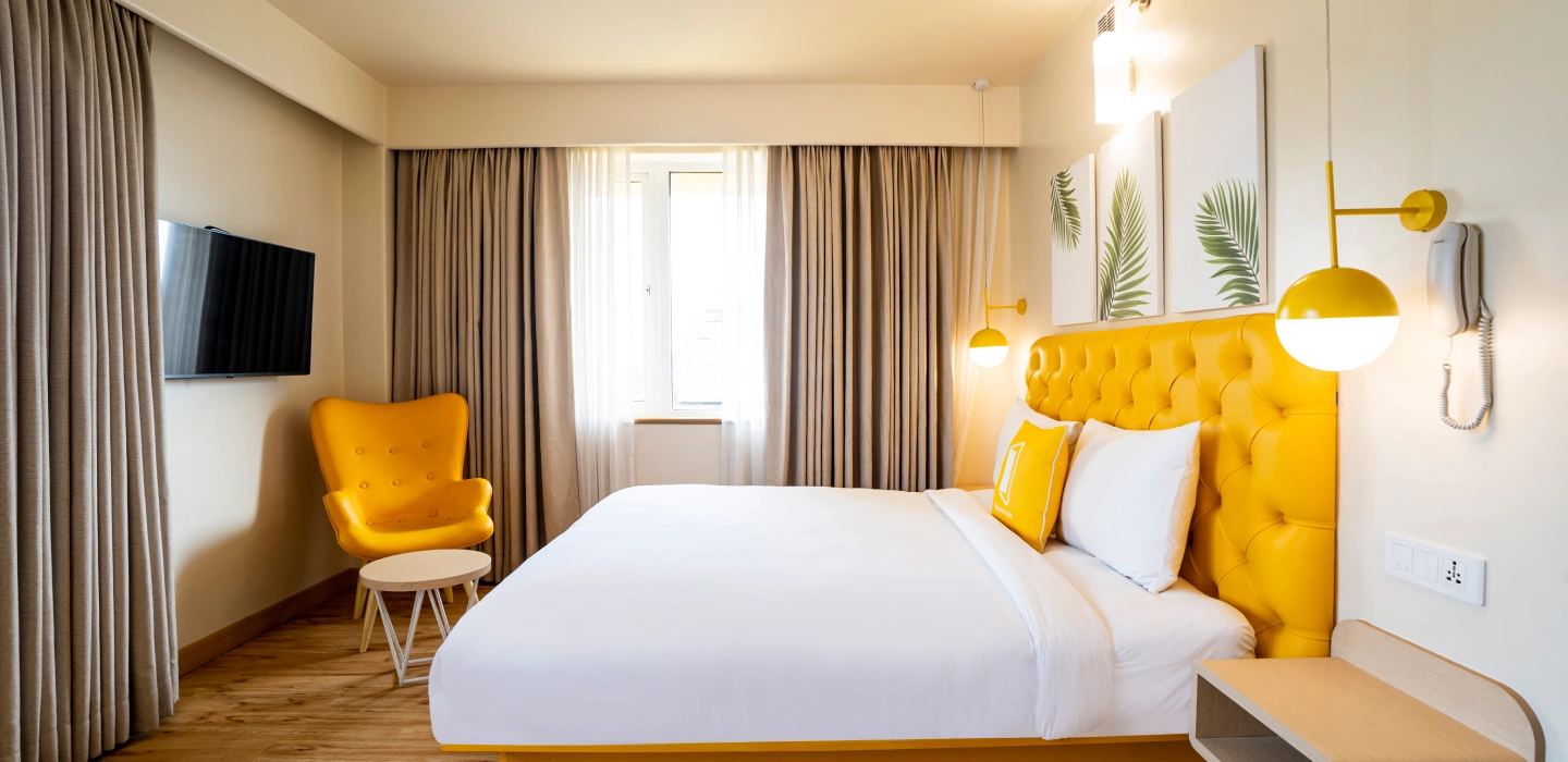 Bright hotel room with yellow accent chair